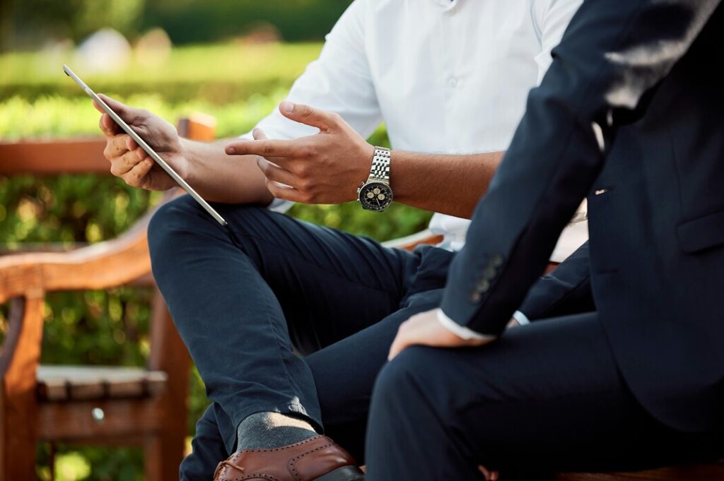 Image of 2 individuals negotiating over a tablet. 