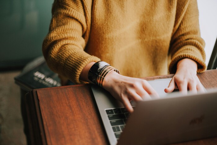 Image of hands on top of a laptop indicating the person is typing.