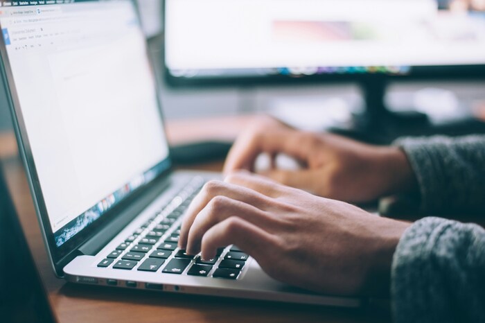 Image of hands on a laptop typing.