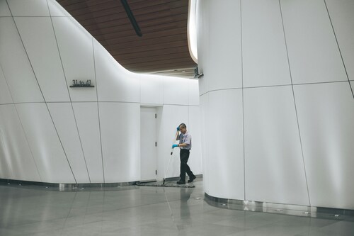 Image of a janitor moping the floor of a building.